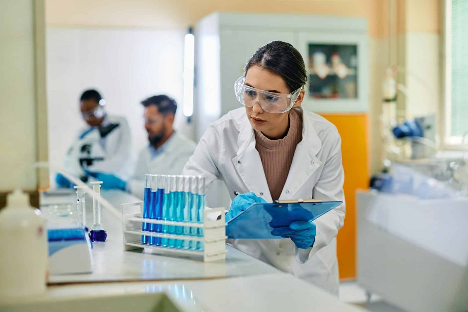 Young female scientist analyzing chemical substances in test tubes in a lab.